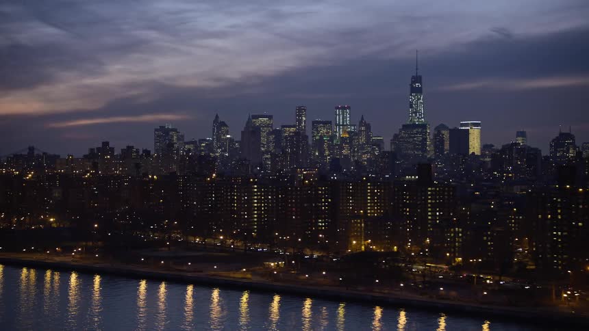 This 4k aerial clip shows public housing complexes in East Village with Lower Manhattan skyline in the background on a winter night