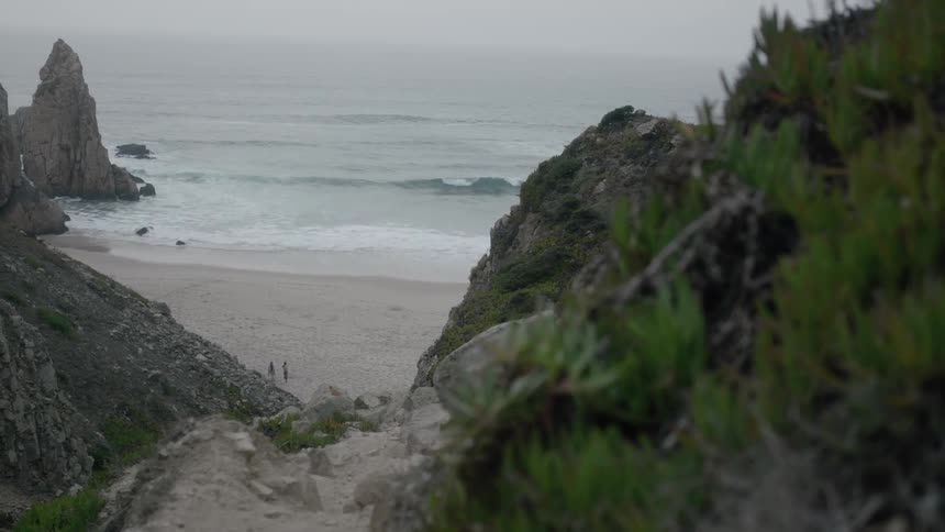 People stand down below on the sand of a beach