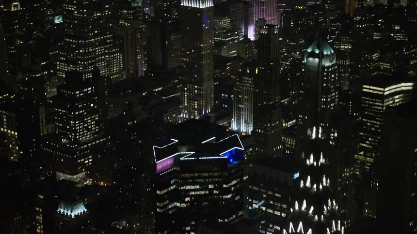 Aerial 4K footage reveals iconic landmarks including the Empire State and Chrysler Buildings as the camera tilts up from the top of the Chrysler Building capturing the clear winter night of Manhattan