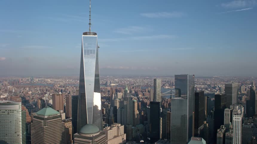 Aerial view of the iconic Freedom Tower in Lower Manhattan towering over other buildings on a sunny winter day in NYC