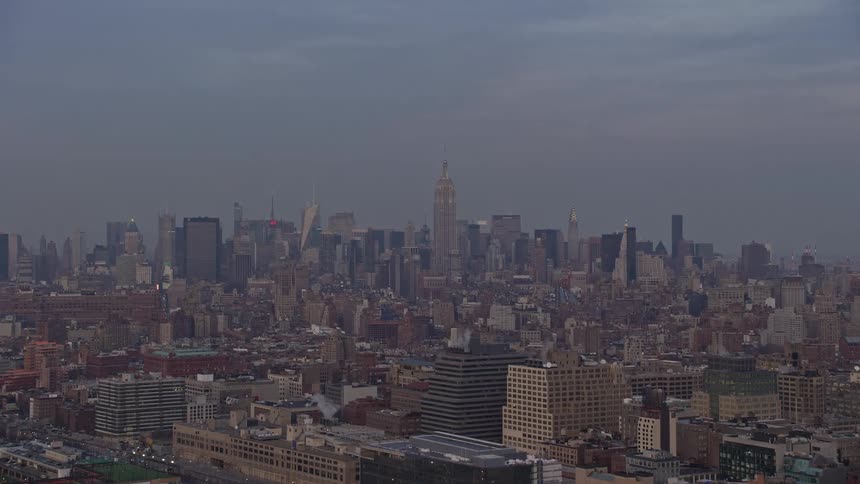 Aerial view of Midtown Manhattan with tall buildings casting a shadow over the city during sunset in the winter as seen from Greenwich Village New York City