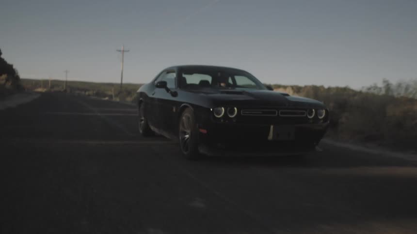 A black car races down a road