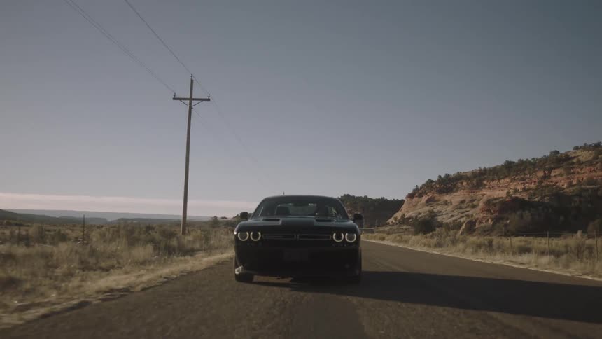 A car speeds down a desert road