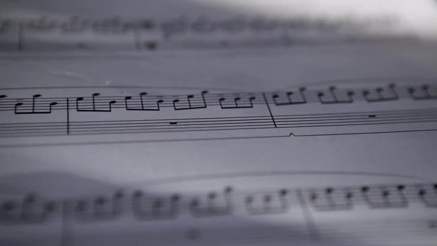 Sunlight shines on sheet music with musical notes on the bars