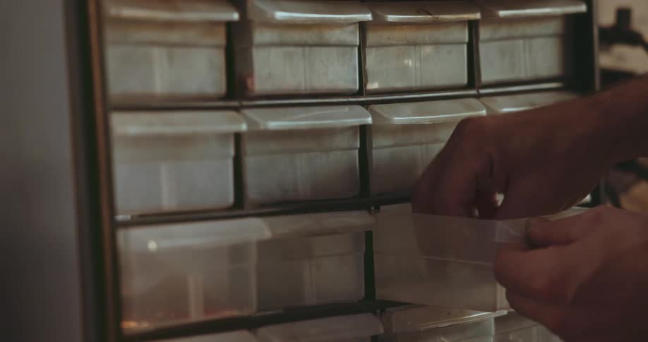 A worker is grabbing a key inside of a container in the day time