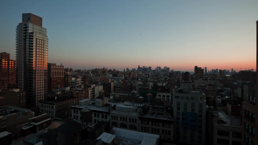 Time lapse view of a downtown city is displayed at sunset