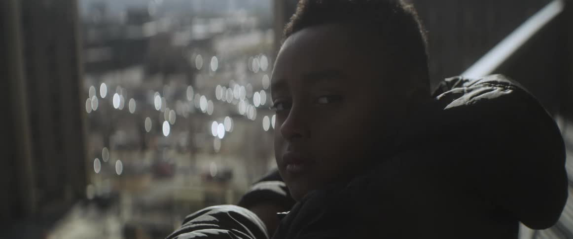 A child is looking at the city skyline outdoors