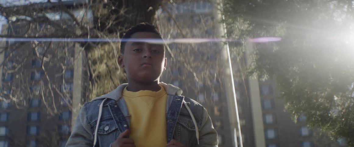 A black male standing outside near trees
