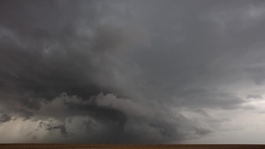 Clouds float across the sky as darker clouds move in and they begin to rotate