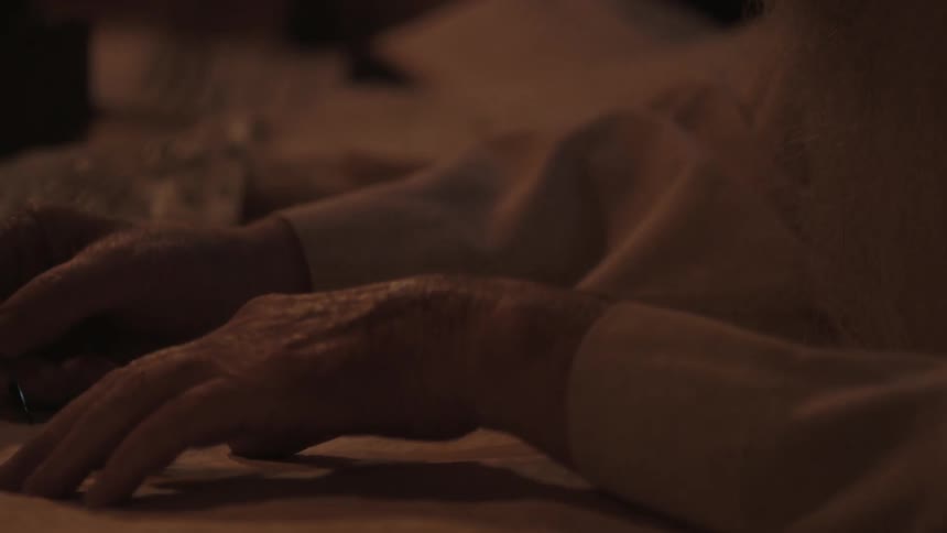 A man is writing by candle light