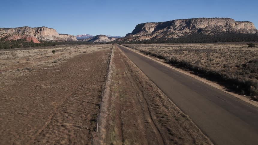 An empty road has mountains in the distance