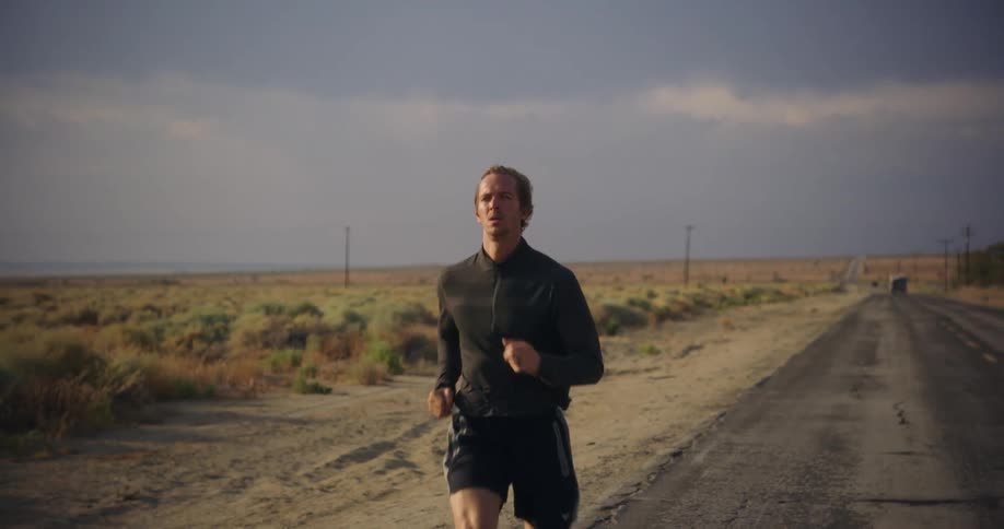 Man jogs down road through countryside