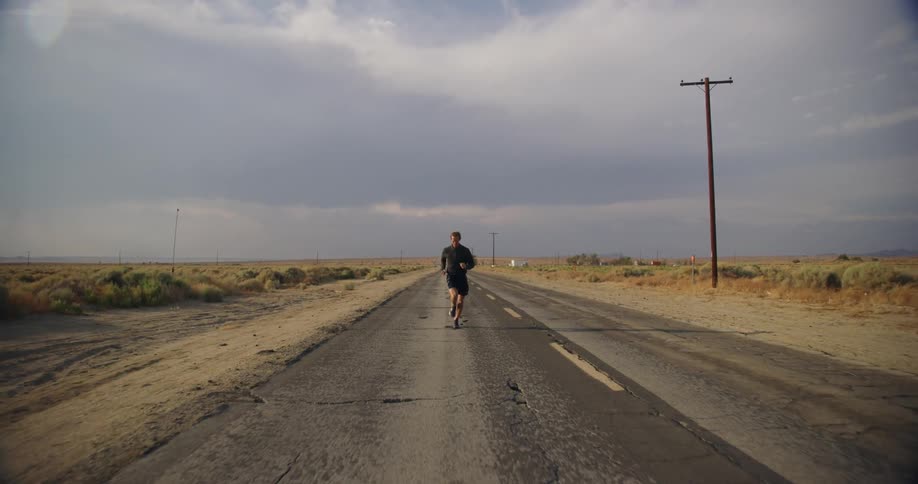 A man is jogging through a rural area during spring