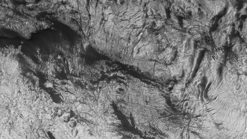 Aerial top down view of a rugged deserted terrain in black and white