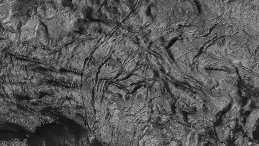 Top down aerial view of the rugged rocky deserted terrain filmed in black and white