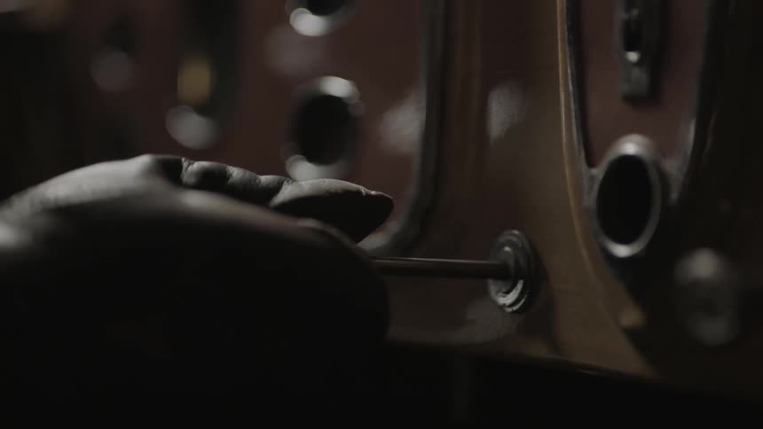 A gloved hand pulls out a lever
