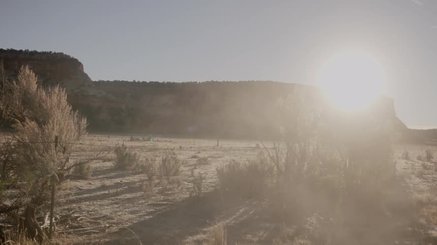 The sun shines down on a dusty desert landscape