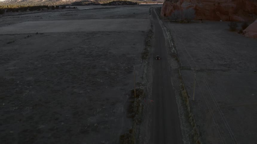 A car drives down a small road below