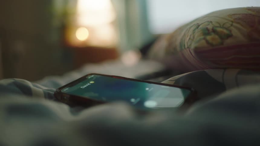 A person picks up their cell phone that is ringing