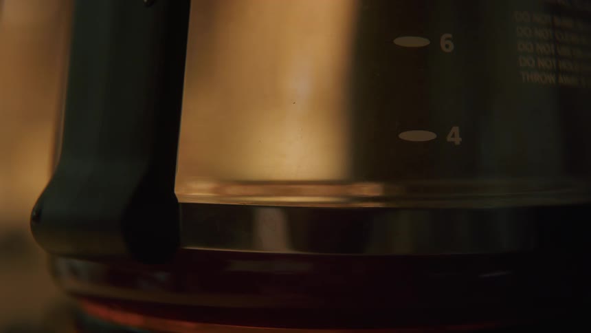 Coffee being brewed and dripping into a glass coffee pot