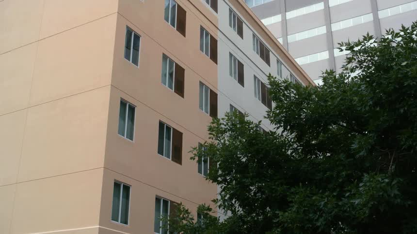 A multistory apartment building in a city on a summer day