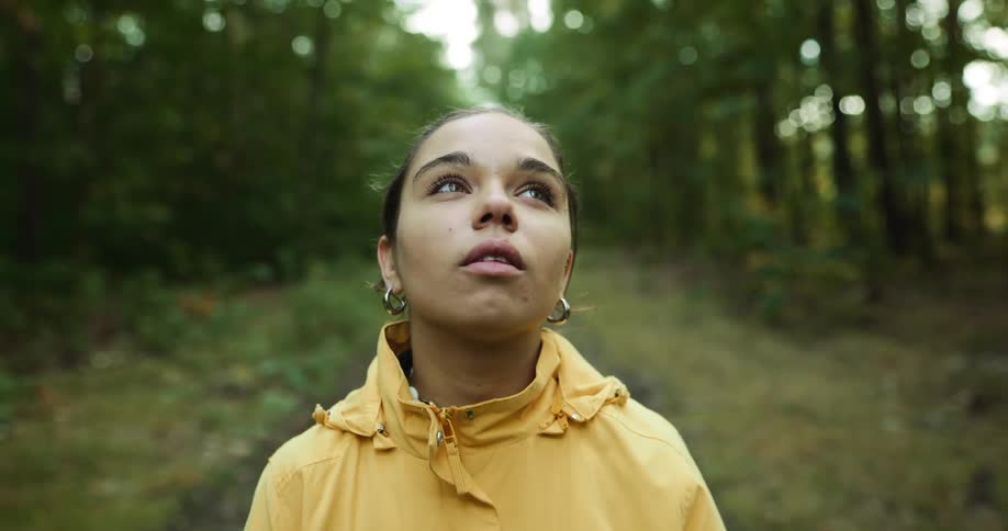 A woman is walking through a forest during the spring