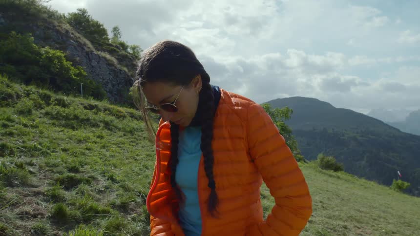 A woman putting on a jacket