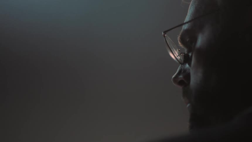 A man wearing glasses turns to the side