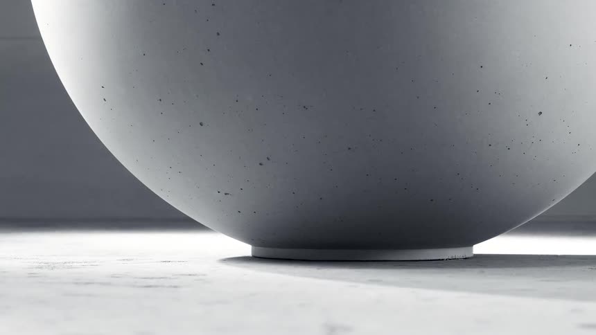 A light moves over a large bowl set on a concrete surface