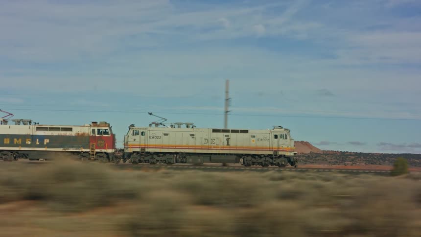 A train traveling on tracks through the desert