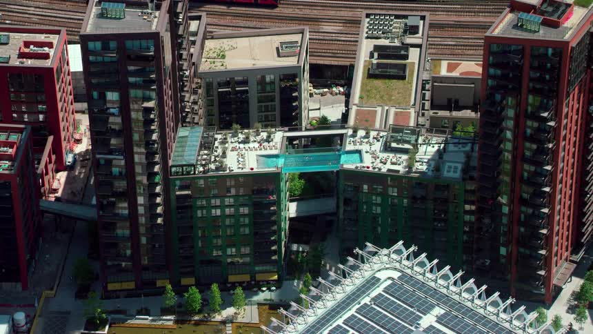 A train runs behind apartment buildings in a city