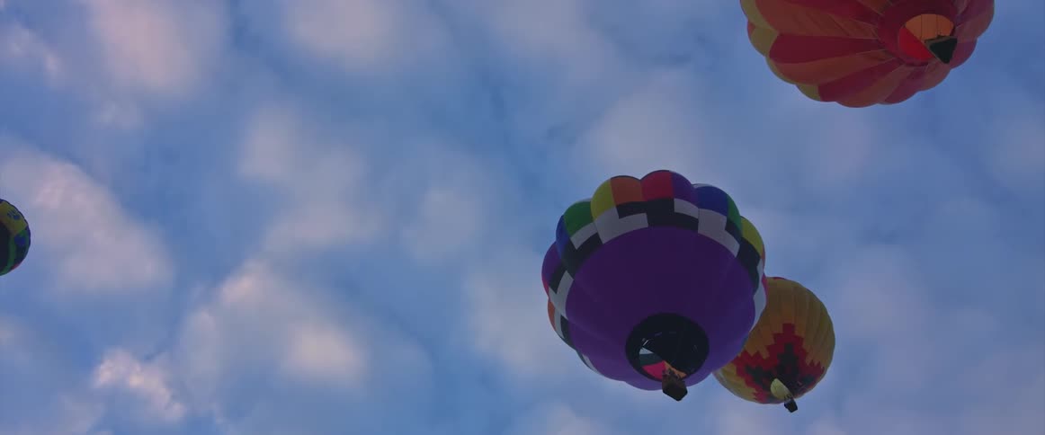 A view of hot air balloons floating in the air