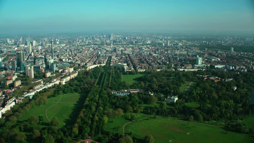 Aerial view of large green public park and skyline of city