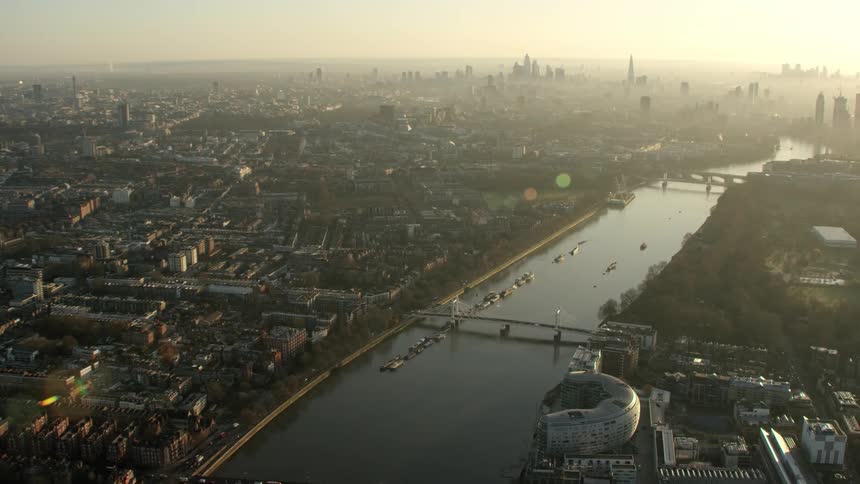 A river through a metropolis shrouded in fog during the day