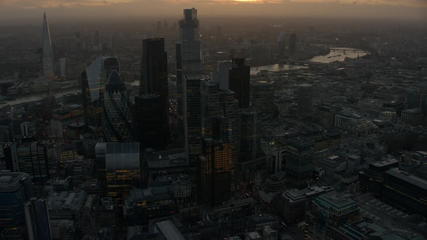 Skyscrapers loom over a metropolis at sunset