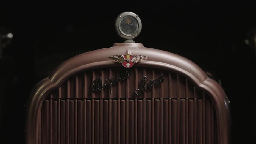 A vintage vehicle is parked in a dark area