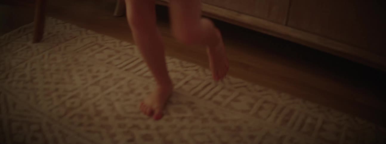 A childs feet dancing around on a beige rug