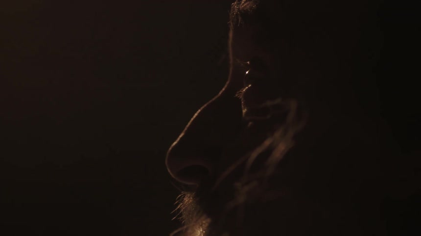 A man is looking forward by a candle