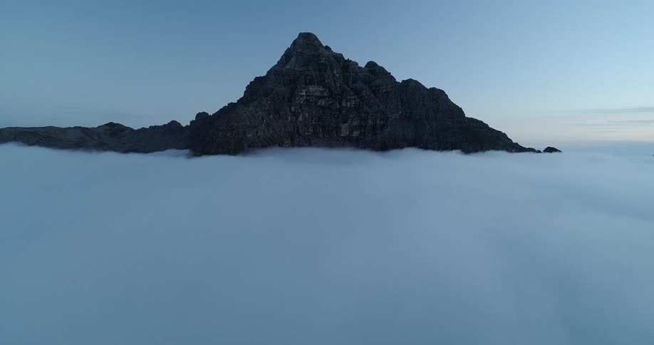 A mountain peak stands high above the clouds