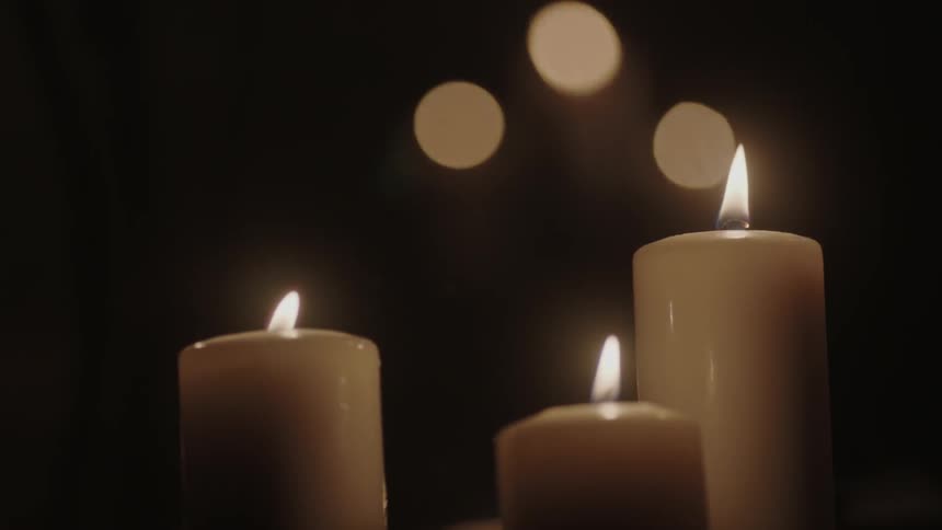 Candles are lit in a dark area