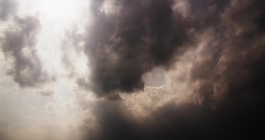 Dark clouds float among white clouds in the sky