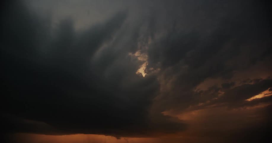Time lapse of dark storm cloud moving across the sunrise