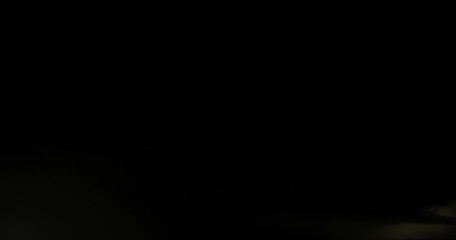 Lightning flashes in the clouds illuminating the dark night sky