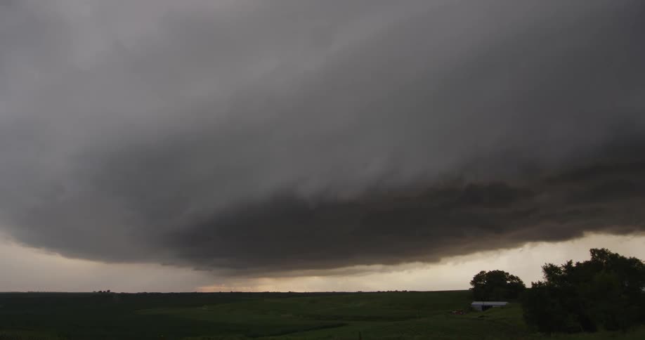 Landscape of green field and dark storms gathering in the sky