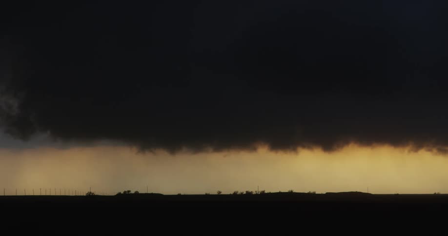 Dark clouds moving slowly over farmland