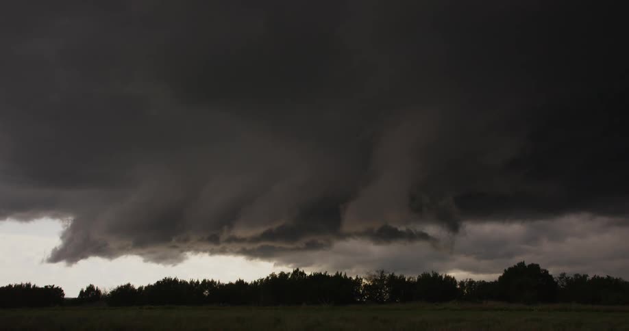 Dark storm thunderstorm clouds rolling over the countryside at daytime