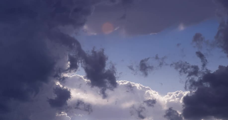 Dark clouds pass underwhite puffy clouds