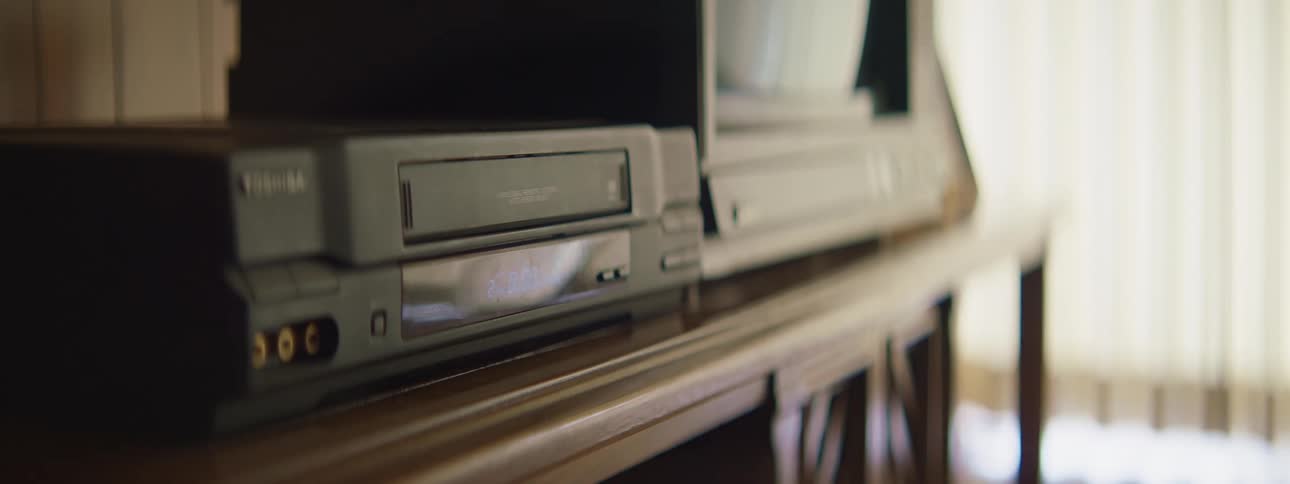 A person placing a cassette inside of a cassette player