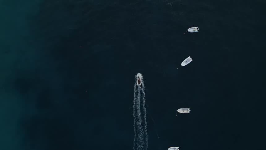 Aerial of a boat cruising alongside other boats in the ocean
