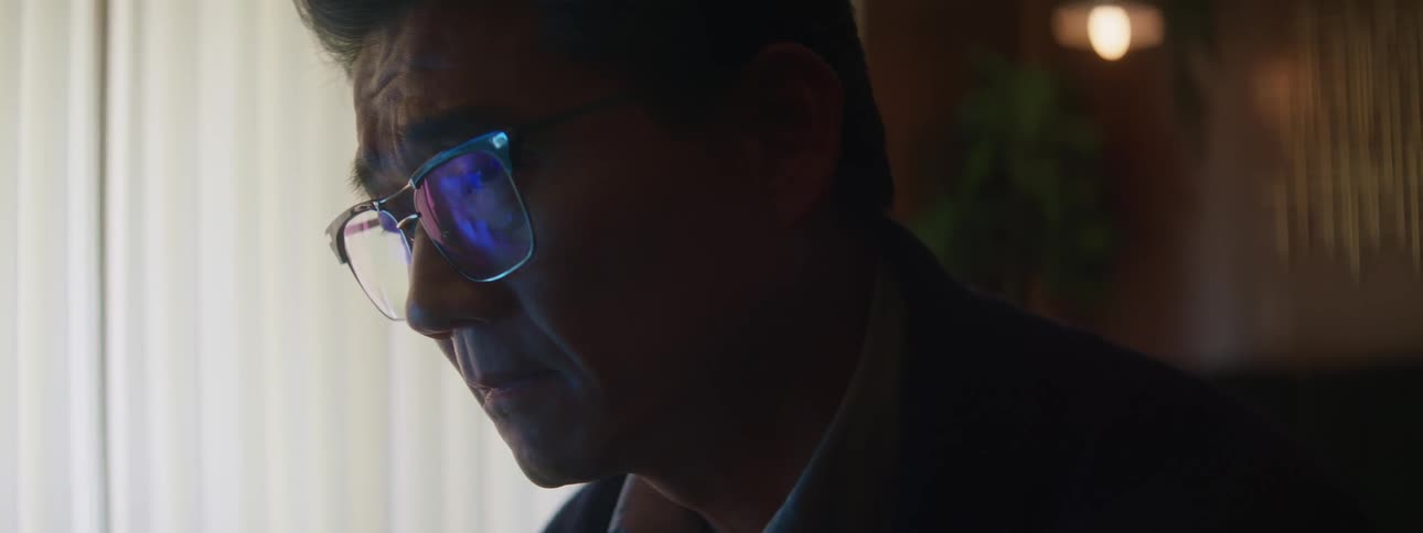 Close up of the face of a man working on a laptop in his home office